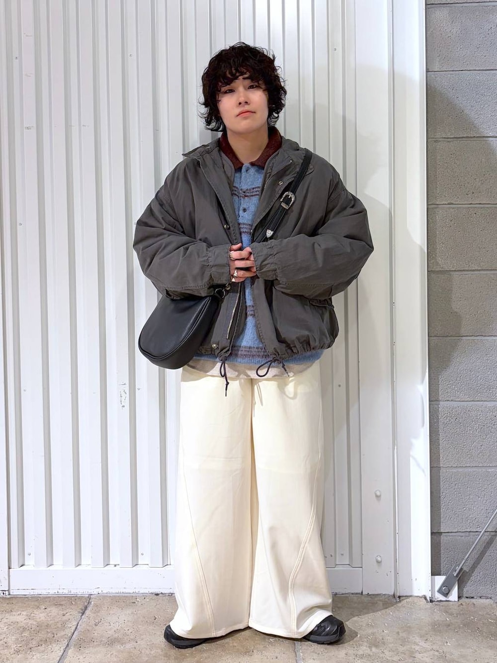 ブラック系のスニーカー、グレー系のモッズコート、ブラック系のショルダーバッグを着用したメンズの冬コーディネートの2枚目の写真