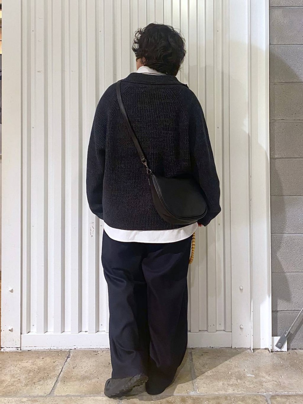 ブラック系のスニーカー、ブラック系のニット/セーター、ブラック系のショルダーバッグを着用したメンズの秋コーディネートの7枚目の写真