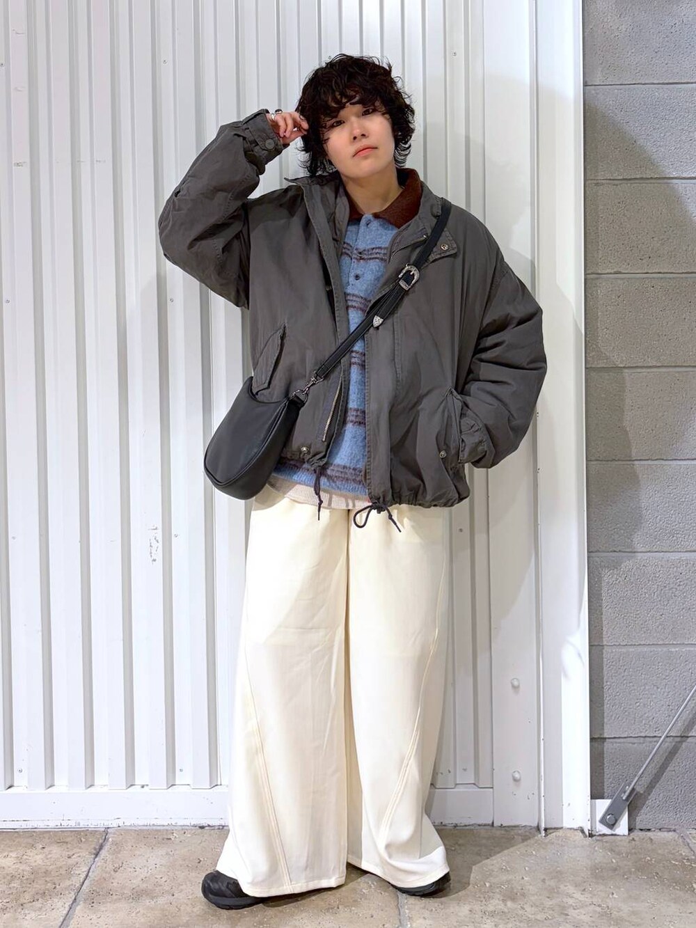 ブラック系のスニーカー、グレー系のモッズコート、ブラック系のショルダーバッグを着用したメンズの冬コーディネートの4枚目の写真