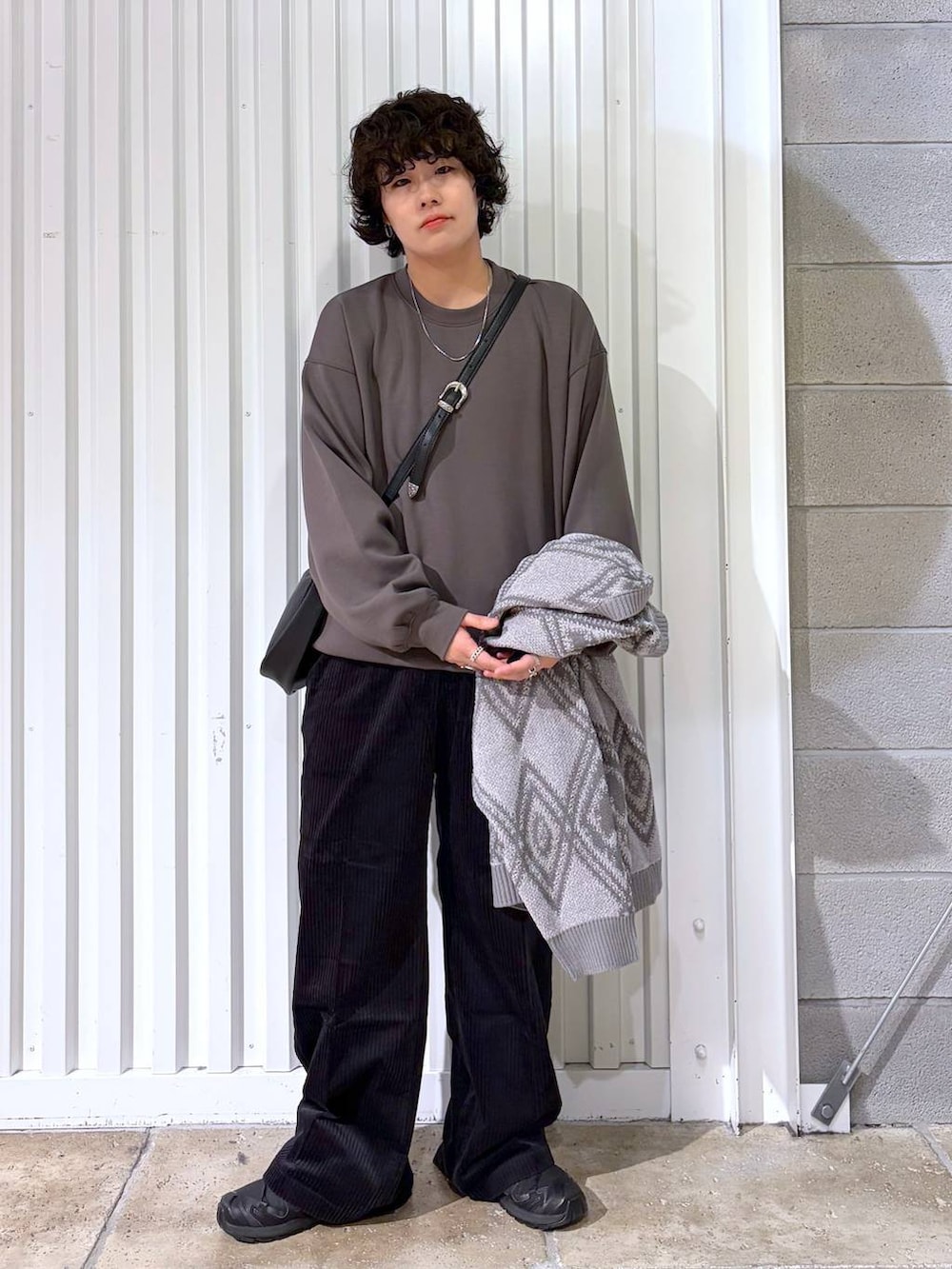 ブラック系のスラックス、ブラウン系のブルゾン、ブラック系のスニーカーを着用したメンズの秋コーディネートの6枚目の写真