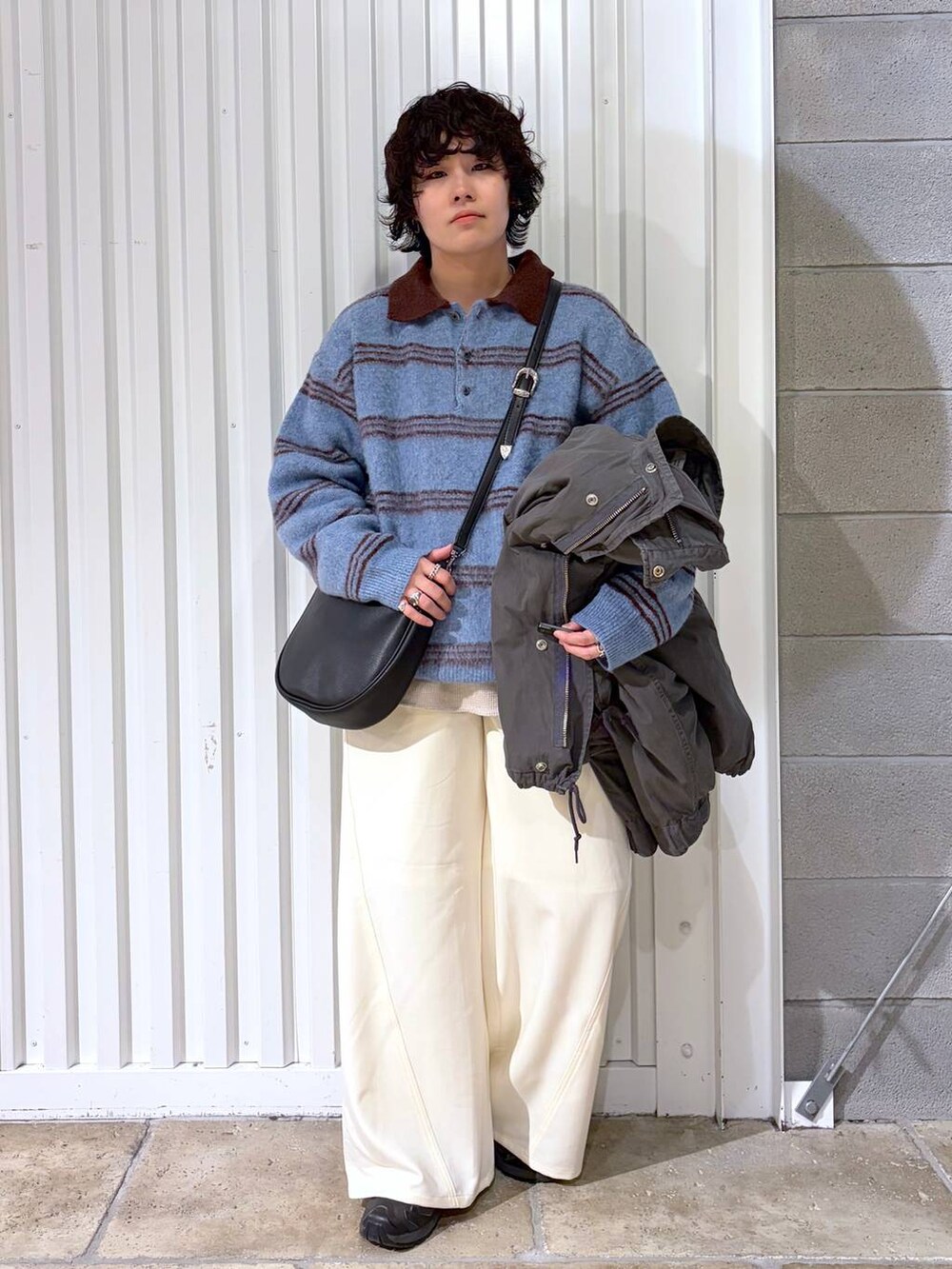 ブラック系のスニーカー、グレー系のモッズコート、ブラック系のショルダーバッグを着用したメンズの冬コーディネートの5枚目の写真