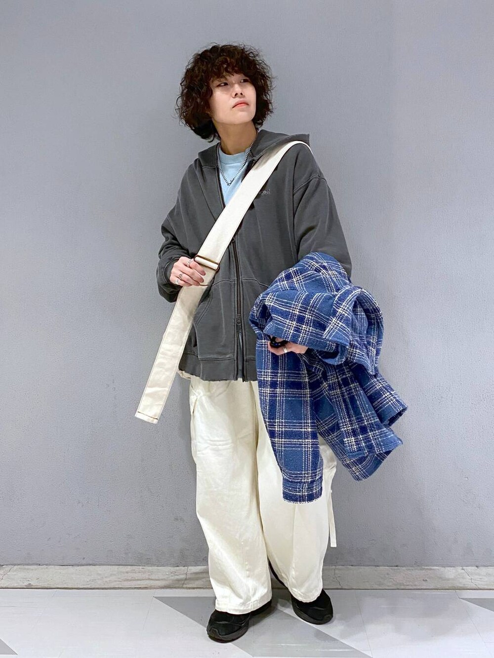 ブラック系のパーカー、ブルー系のTシャツ/カットソー、ホワイト系のカーゴパンツを着用したメンズの冬コーディネートの2枚目の写真