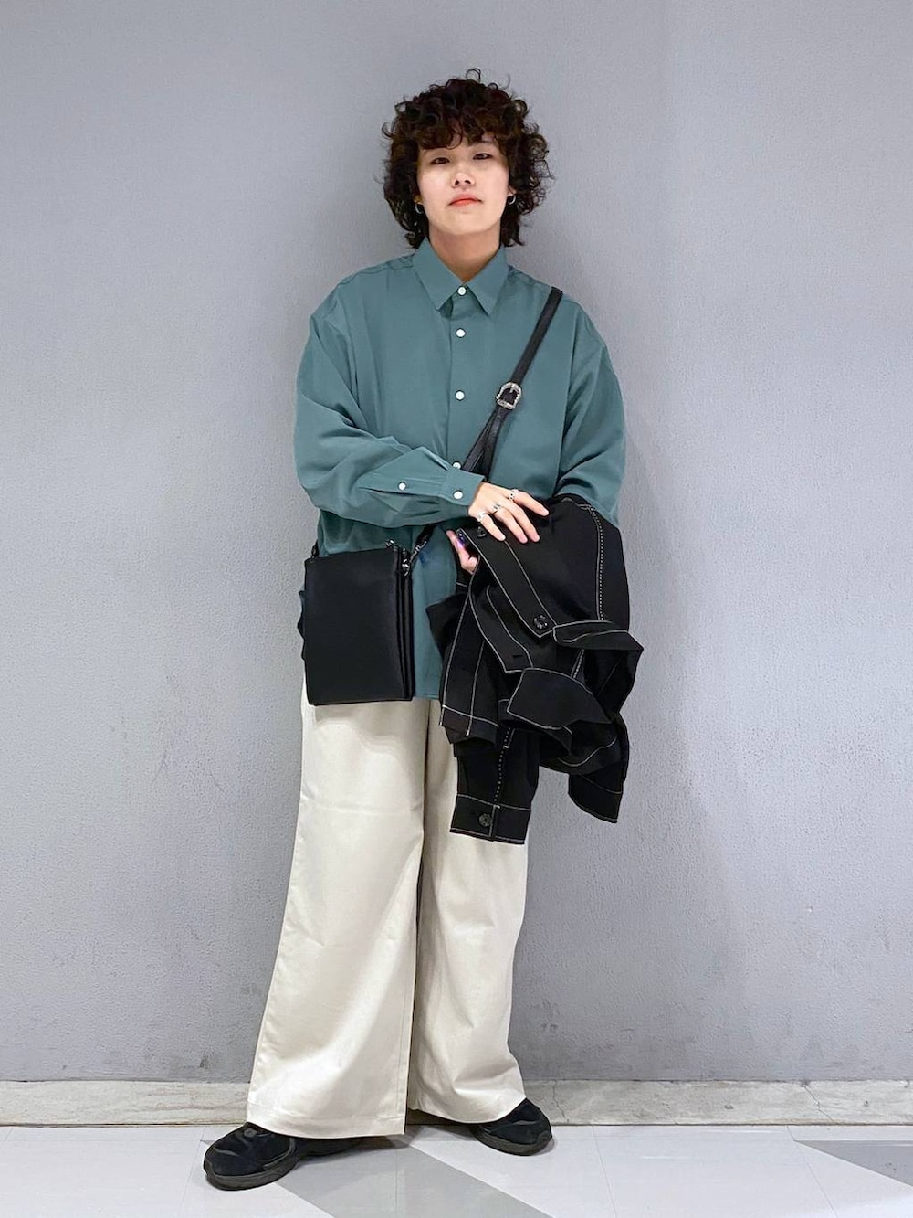 ホワイト系のスラックス、グリーン系のシャツ/ブラウス、その他のショルダーバッグを着用したメンズの秋コーディネートの2枚目の写真