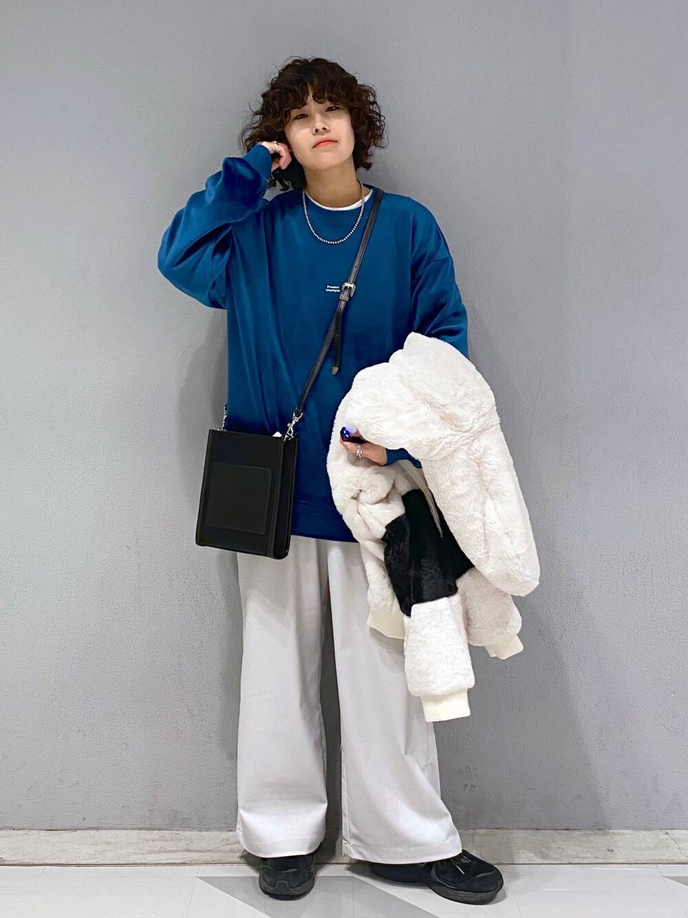 ブルー系のスウェット、ホワイト系のブルゾン、ブラック系のショルダーバッグを着用したメンズの冬コーディネートの5枚目の写真