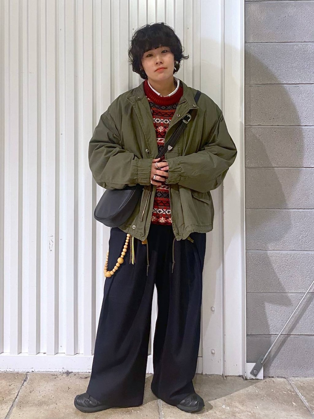 ブラック系のスニーカー、グリーン系のテーラードジャケット、ブラック系のショルダーバッグを着用したメンズの秋コーディネートの2枚目の写真