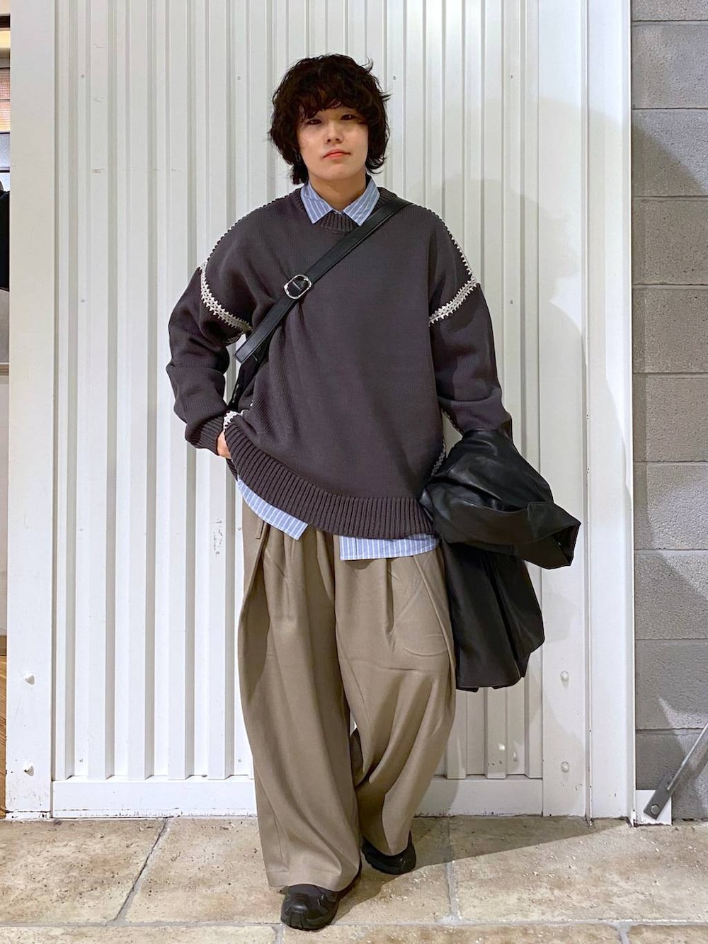 ブラック系のスニーカー、ブラック系のショルダーバッグ、ブルー系のシャツ/ブラウスを着用したメンズの冬コーディネートの2枚目の写真