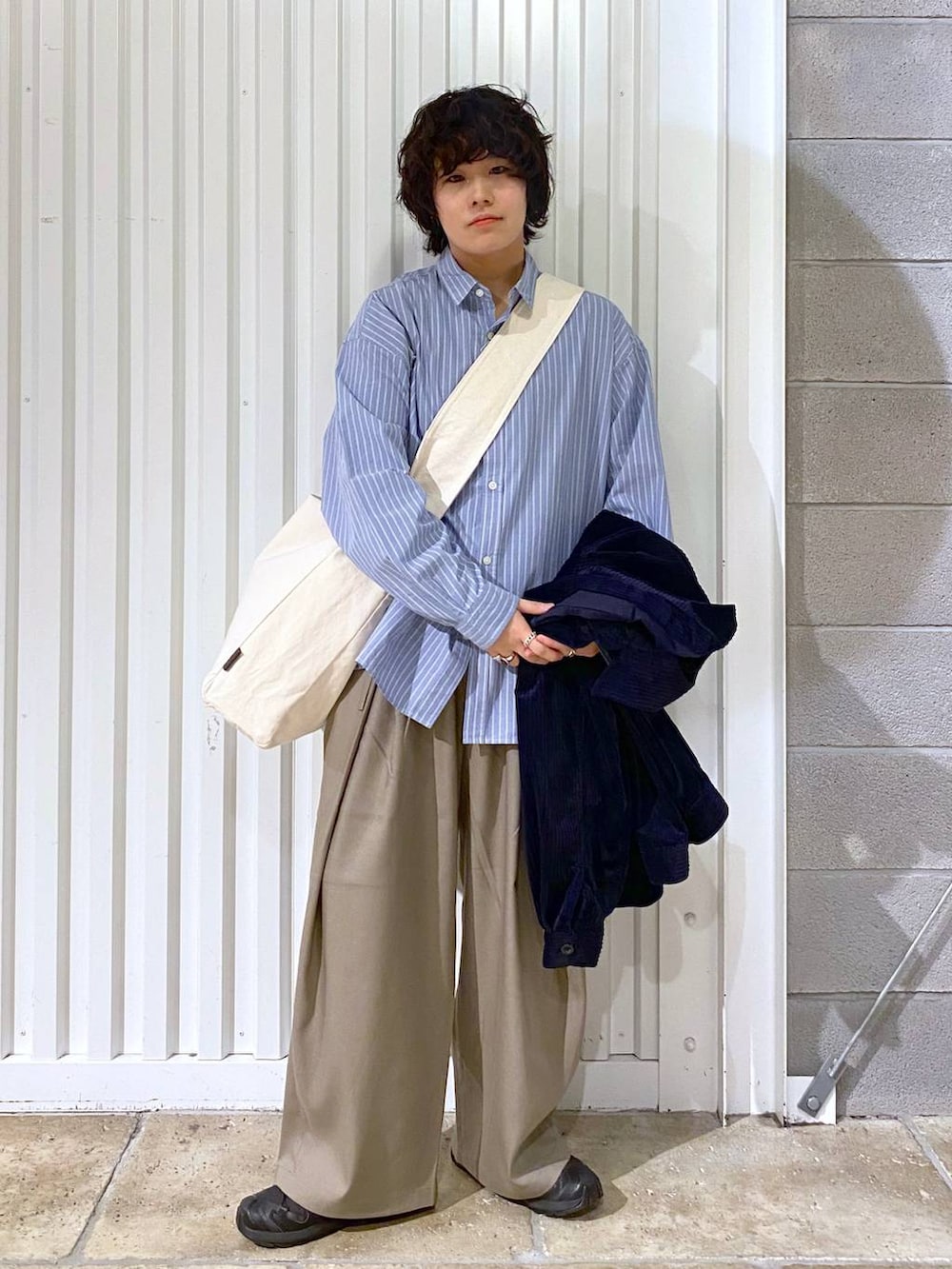 ブラック系のスニーカー、ブルー系のシャツ/ブラウス、その他のショルダーバッグを着用したメンズの秋コーディネートの2枚目の写真