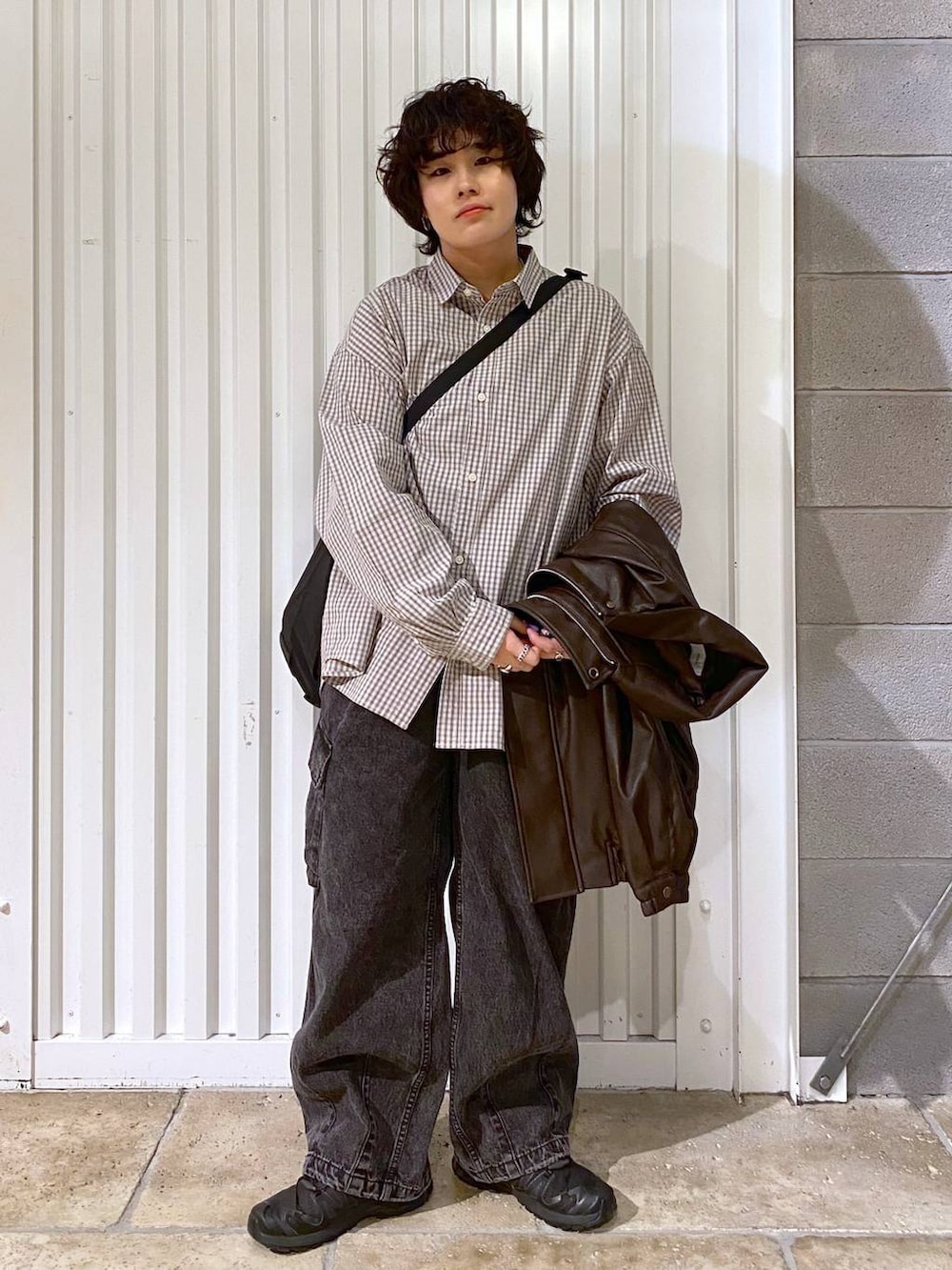 ブラック系のショルダーバッグ、ブラウン系のブルゾン、ブラック系のスニーカーを着用したメンズの秋コーディネートの3枚目の写真