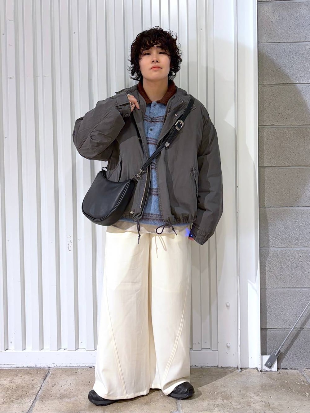 ブラック系のスニーカー、グレー系のモッズコート、ブラック系のショルダーバッグを着用したメンズの冬コーディネートの3枚目の写真