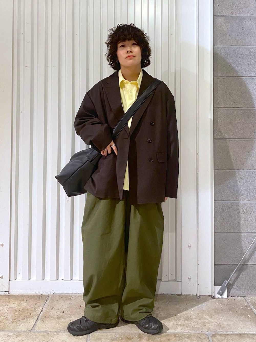 ブラック系のショルダーバッグ、ブラック系のスニーカー、ブラウン系のテーラードジャケットを着用したメンズの秋コーディネートの3枚目の写真