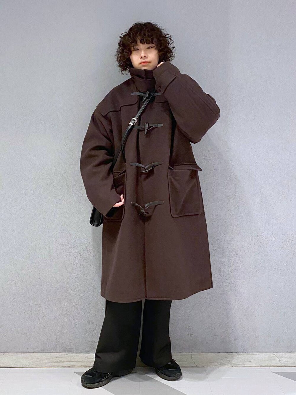 ブラウン系のダッフルコート、ブラウン系のカーディガン/ボレロ、ホワイト系のスウェットを着用したメンズの冬コーディネートの7枚目の写真