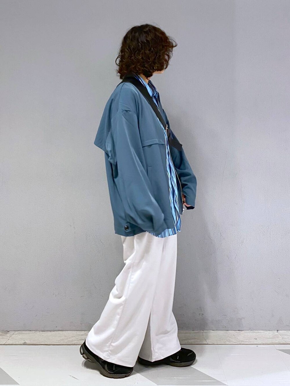 ブラック系のショルダーバッグ、ホワイト系のスラックス、ブルー系のブルゾンを着用したメンズの春コーディネートの8枚目の写真