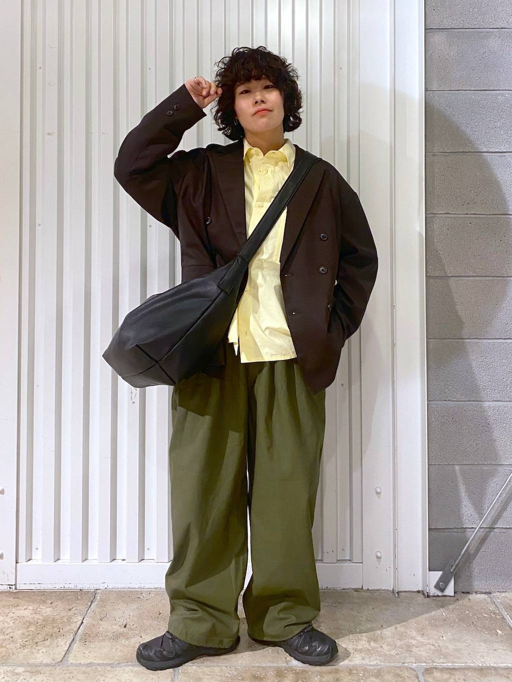 ブラック系のショルダーバッグ、ブラック系のスニーカー、ブラウン系のテーラードジャケットを着用したメンズの秋コーディネートの2枚目の写真