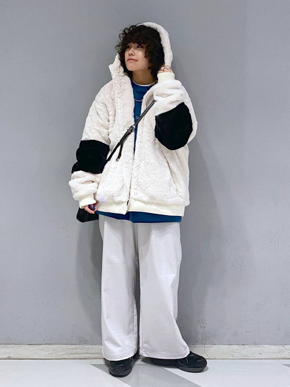 ブルー系のスウェット、ホワイト系のブルゾン、ブラック系のショルダーバッグを着用したメンズの冬コーディネートの4枚目の写真