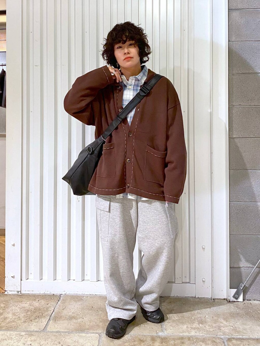 ブラック系のショルダーバッグ、ブラック系のスニーカー、ブラウン系のカーディガン/ボレロを着用したメンズの秋コーディネートの3枚目の写真