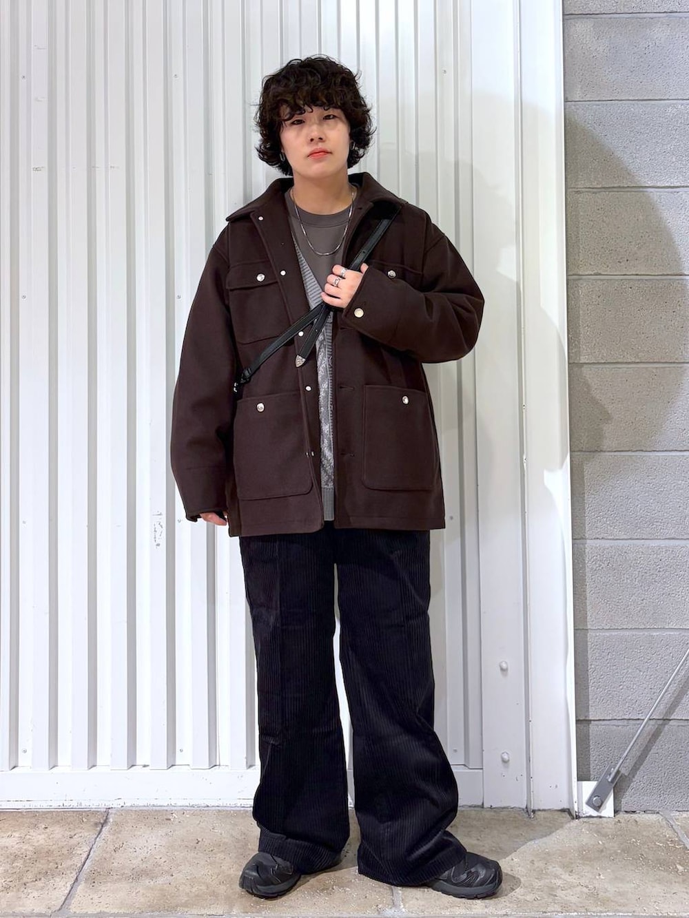 ブラック系のスラックス、ブラウン系のブルゾン、ブラック系のスニーカーを着用したメンズの秋コーディネートの4枚目の写真