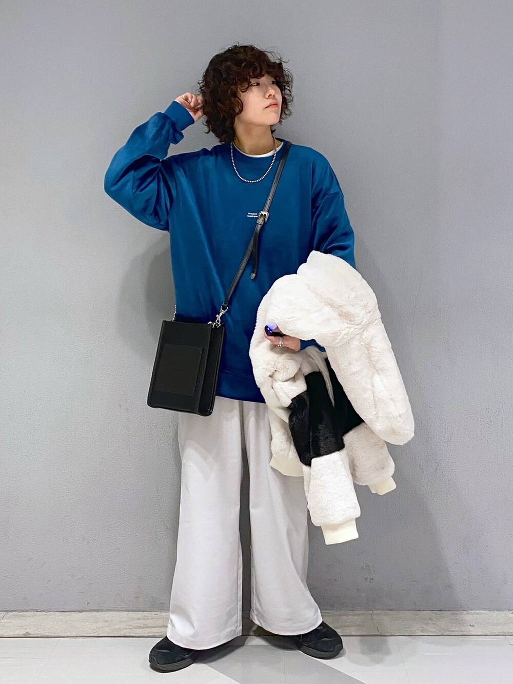 ブルー系のスウェット、ホワイト系のブルゾン、ブラック系のショルダーバッグを着用したメンズの冬コーディネートの4枚目の写真