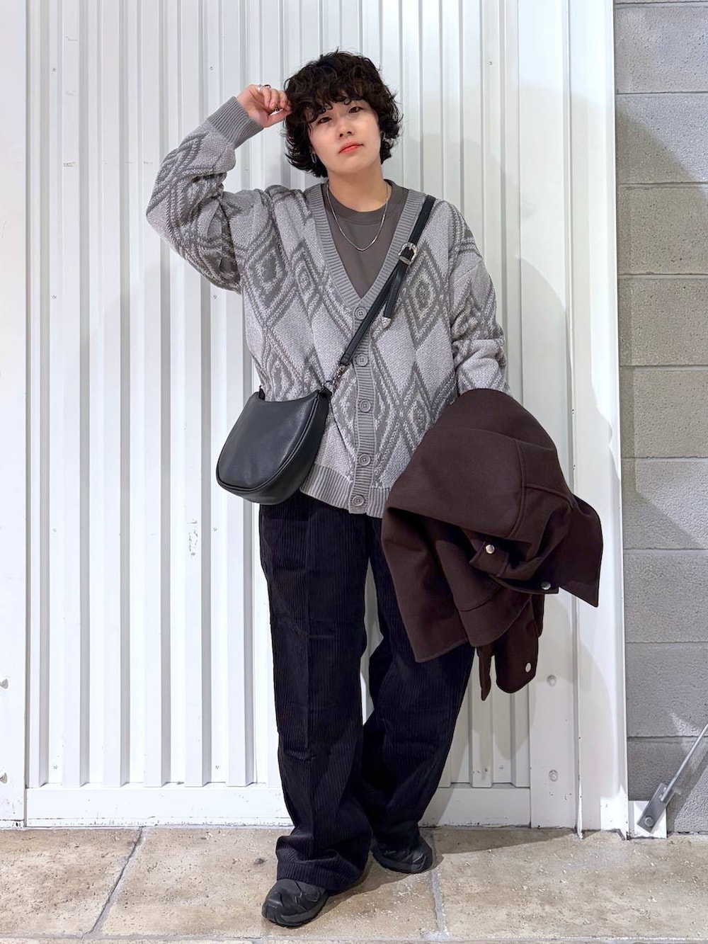 ブラック系のスラックス、ブラウン系のブルゾン、ブラック系のスニーカーを着用したメンズの秋コーディネートの2枚目の写真