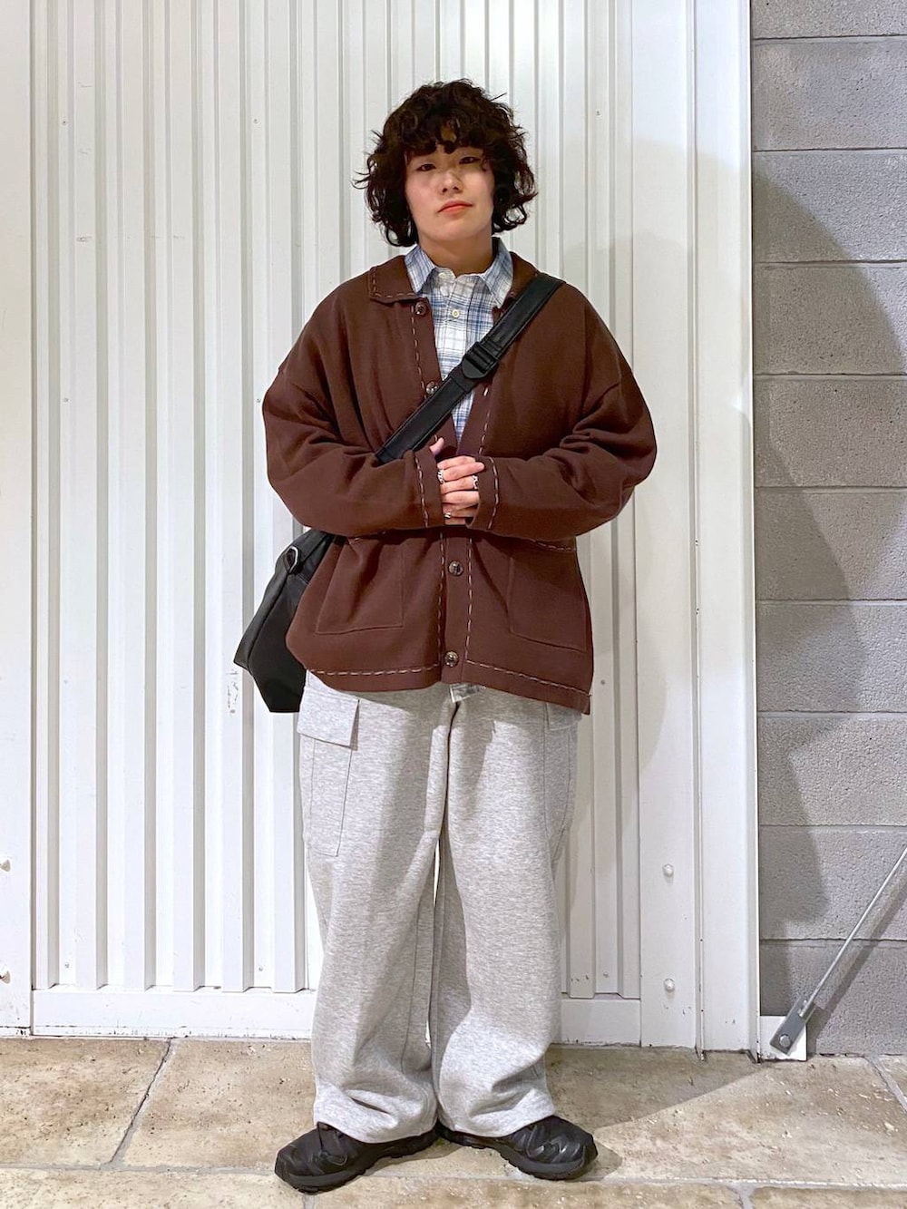 ブラック系のショルダーバッグ、ブラック系のスニーカー、ブラウン系のカーディガン/ボレロを着用したメンズの秋コーディネートの2枚目の写真