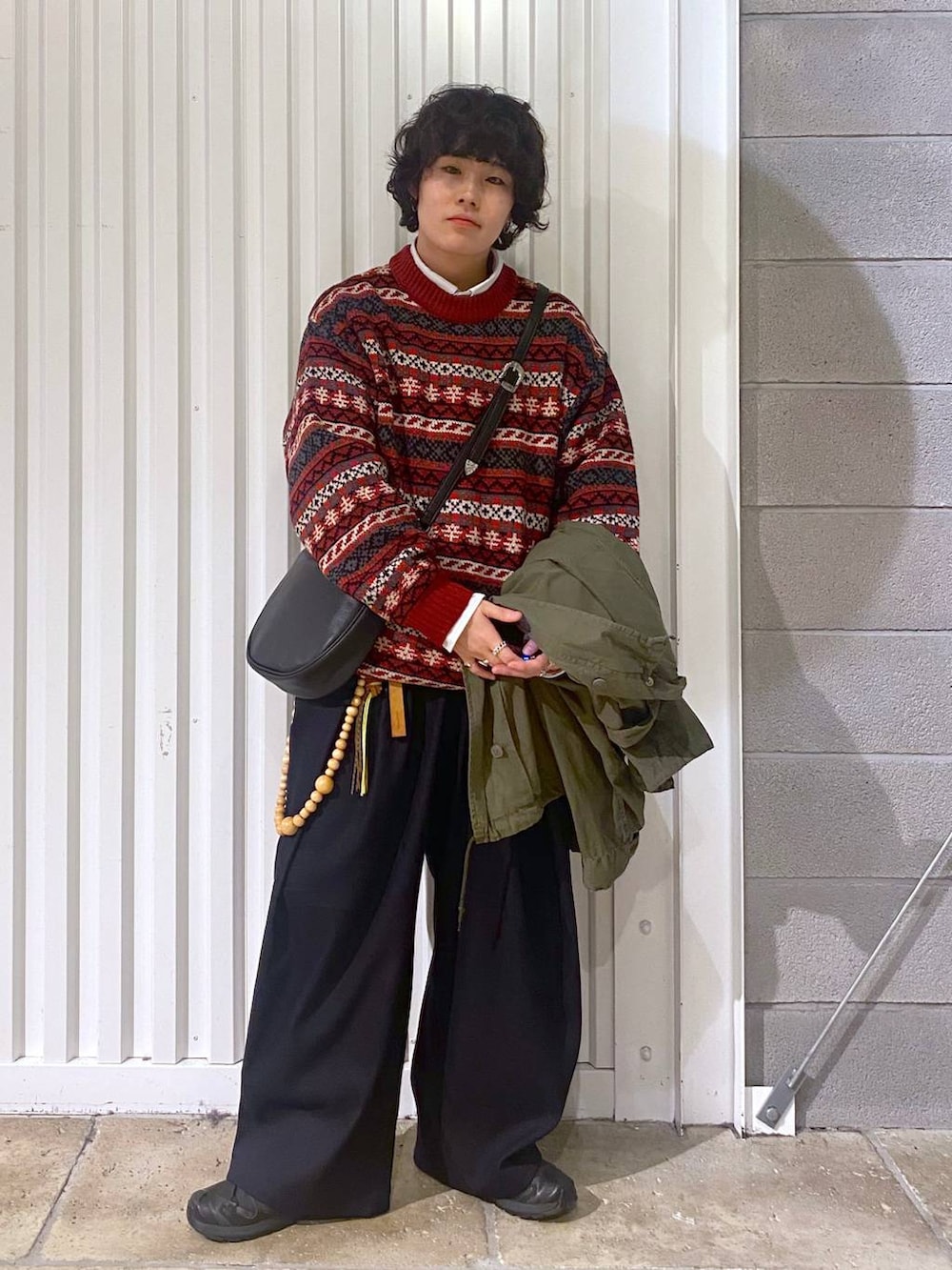 ブラック系のスニーカー、グリーン系のテーラードジャケット、ブラック系のショルダーバッグを着用したメンズの秋コーディネートの4枚目の写真