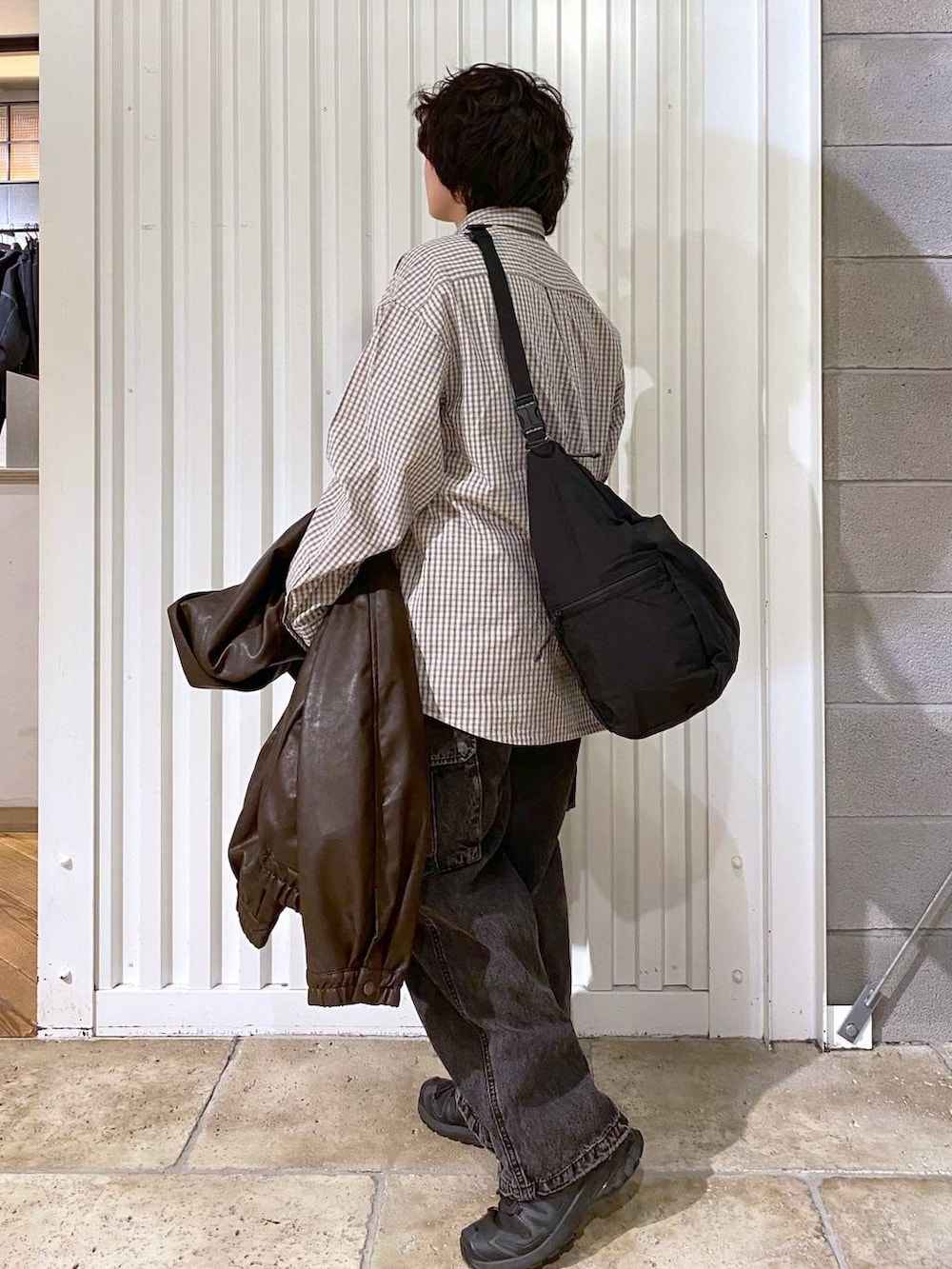 ブラック系のショルダーバッグ、ブラウン系のブルゾン、ブラック系のスニーカーを着用したメンズの秋コーディネートの7枚目の写真