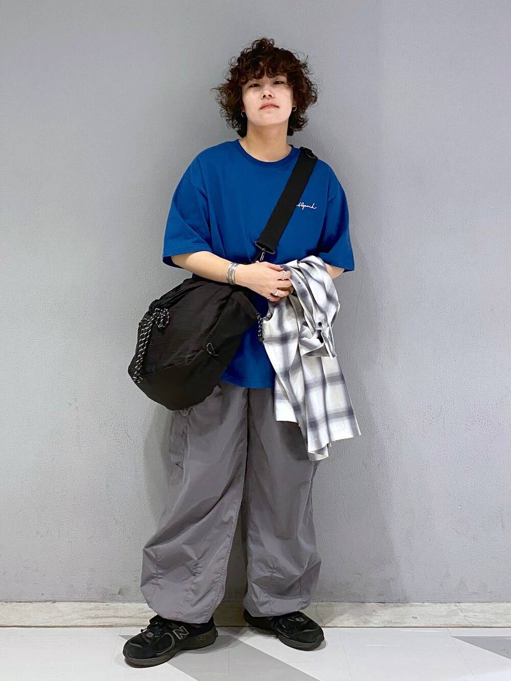 ブラック系のショルダーバッグ、グレー系のカーゴパンツ、ブルー系のTシャツ/カットソーを着用したメンズの夏コーディネートの2枚目の写真