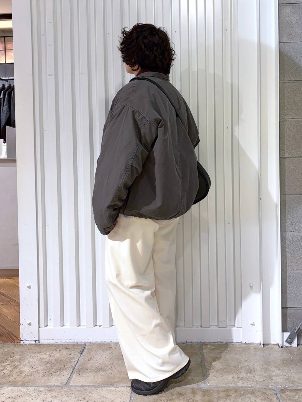 ブラック系のスニーカー、グレー系のモッズコート、ブラック系のショルダーバッグを着用したメンズの冬コーディネートの7枚目の写真