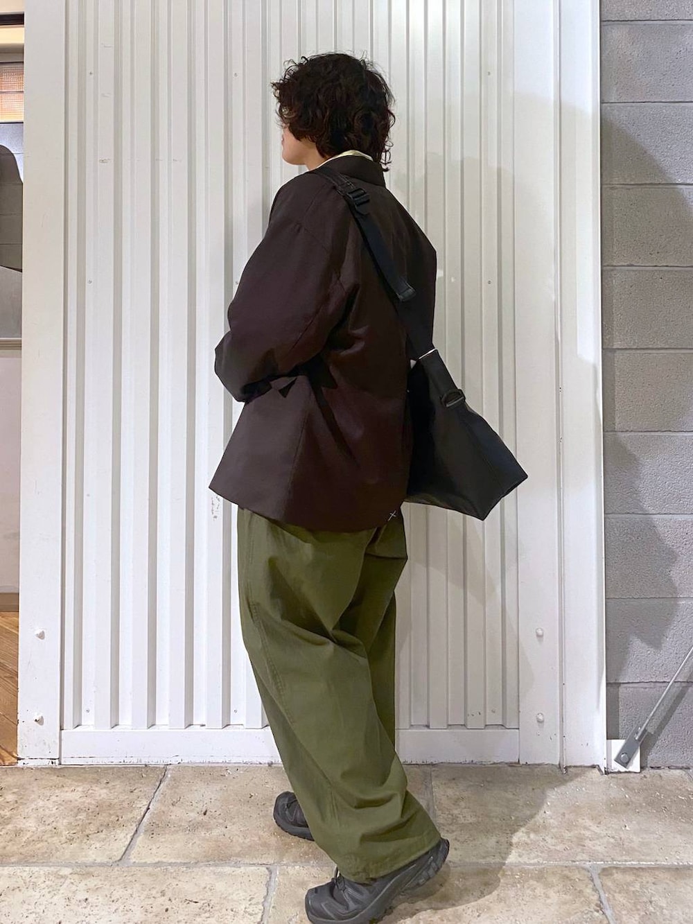 ブラック系のショルダーバッグ、ブラック系のスニーカー、ブラウン系のテーラードジャケットを着用したメンズの秋コーディネートの6枚目の写真