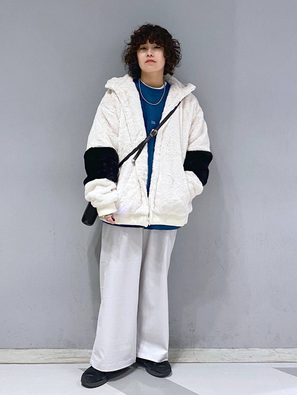 ブルー系のスウェット、ホワイト系のブルゾン、ブラック系のショルダーバッグを着用したメンズの冬コーディネートの5枚目の写真