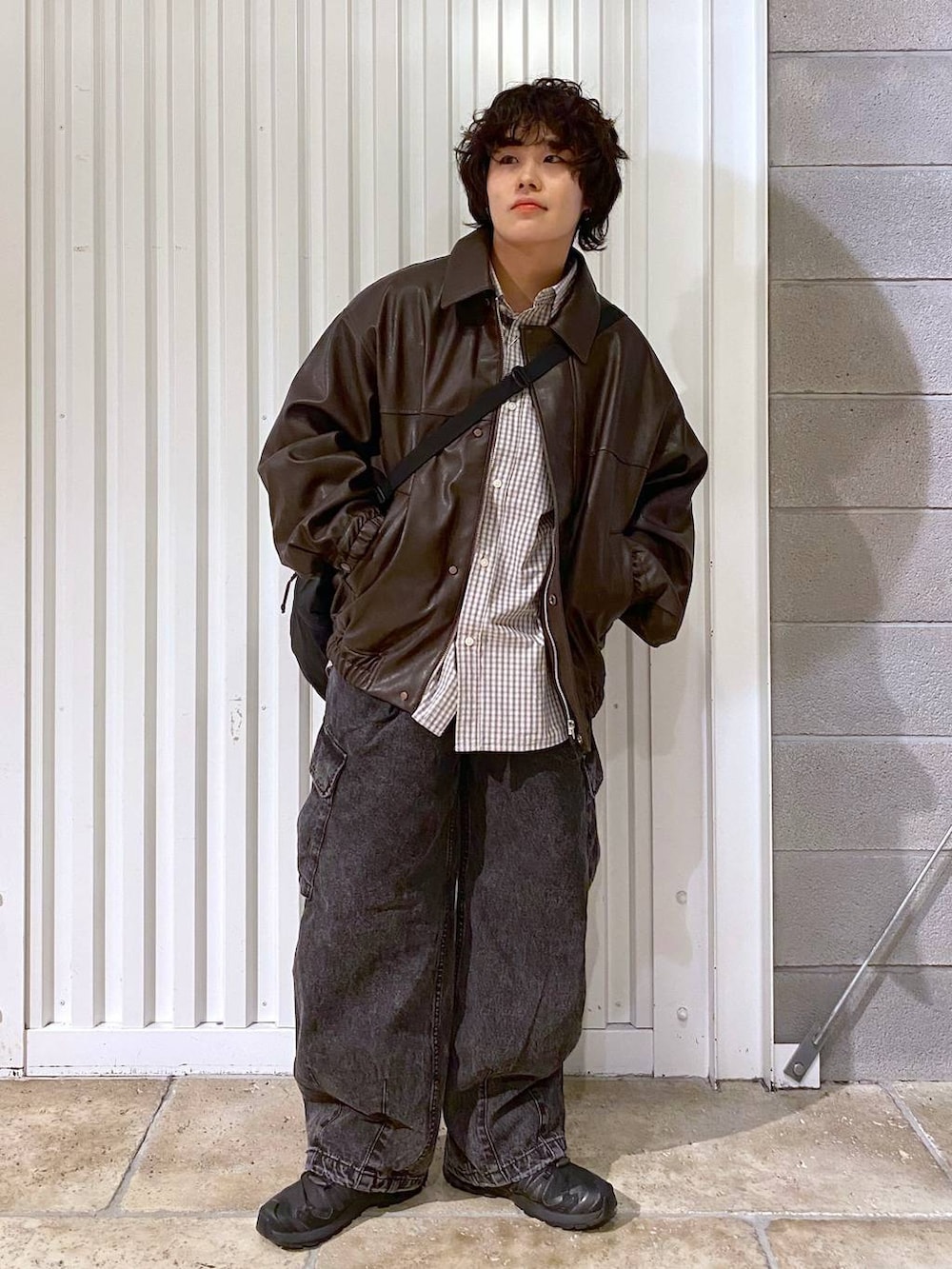 ブラック系のショルダーバッグ、ブラウン系のブルゾン、ブラック系のスニーカーを着用したメンズの秋コーディネートの4枚目の写真