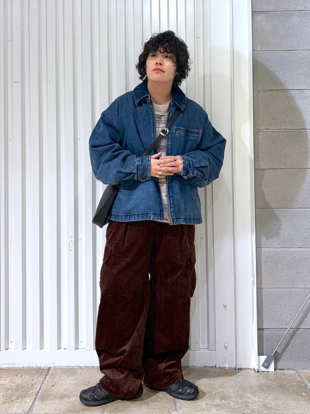 ブラウン系のカーゴパンツ、ブラック系のスニーカー、ブラック系のショルダーバッグを着用したメンズの冬コーディネートの2枚目の写真