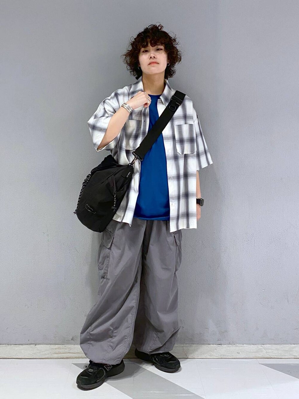 ブラック系のショルダーバッグ、グレー系のカーゴパンツ、ブルー系のTシャツ/カットソーを着用したメンズの夏コーディネートの7枚目の写真