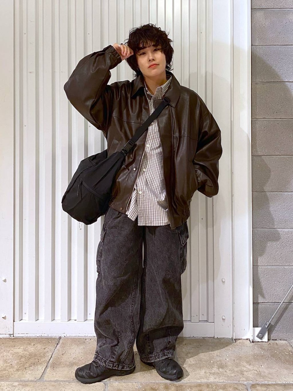 ブラック系のショルダーバッグ、ブラウン系のブルゾン、ブラック系のスニーカーを着用したメンズの秋コーディネートの5枚目の写真