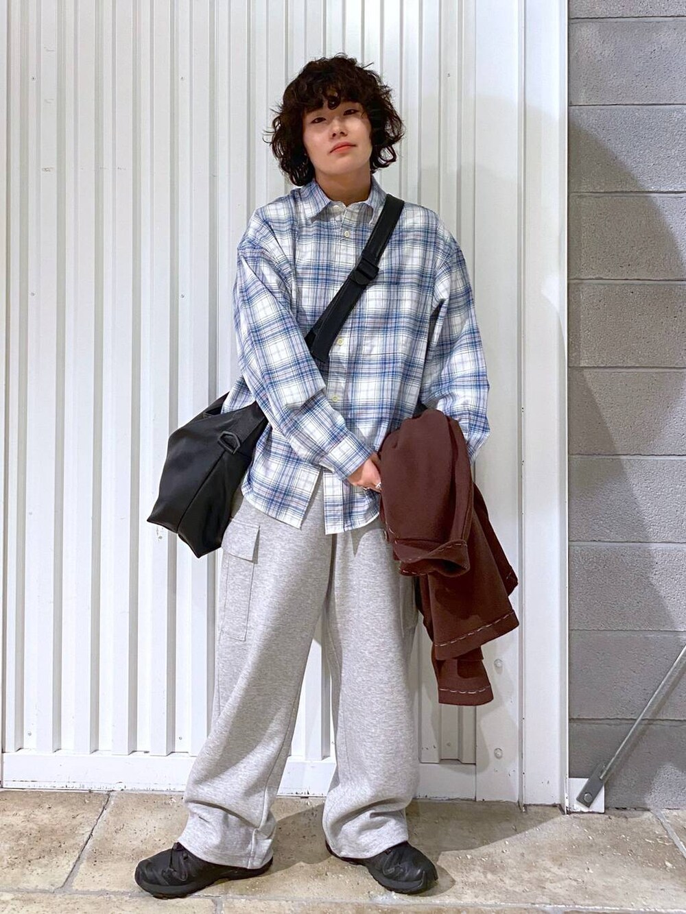 ブラック系のショルダーバッグ、ブラック系のスニーカー、ブラウン系のカーディガン/ボレロを着用したメンズの秋コーディネートの5枚目の写真