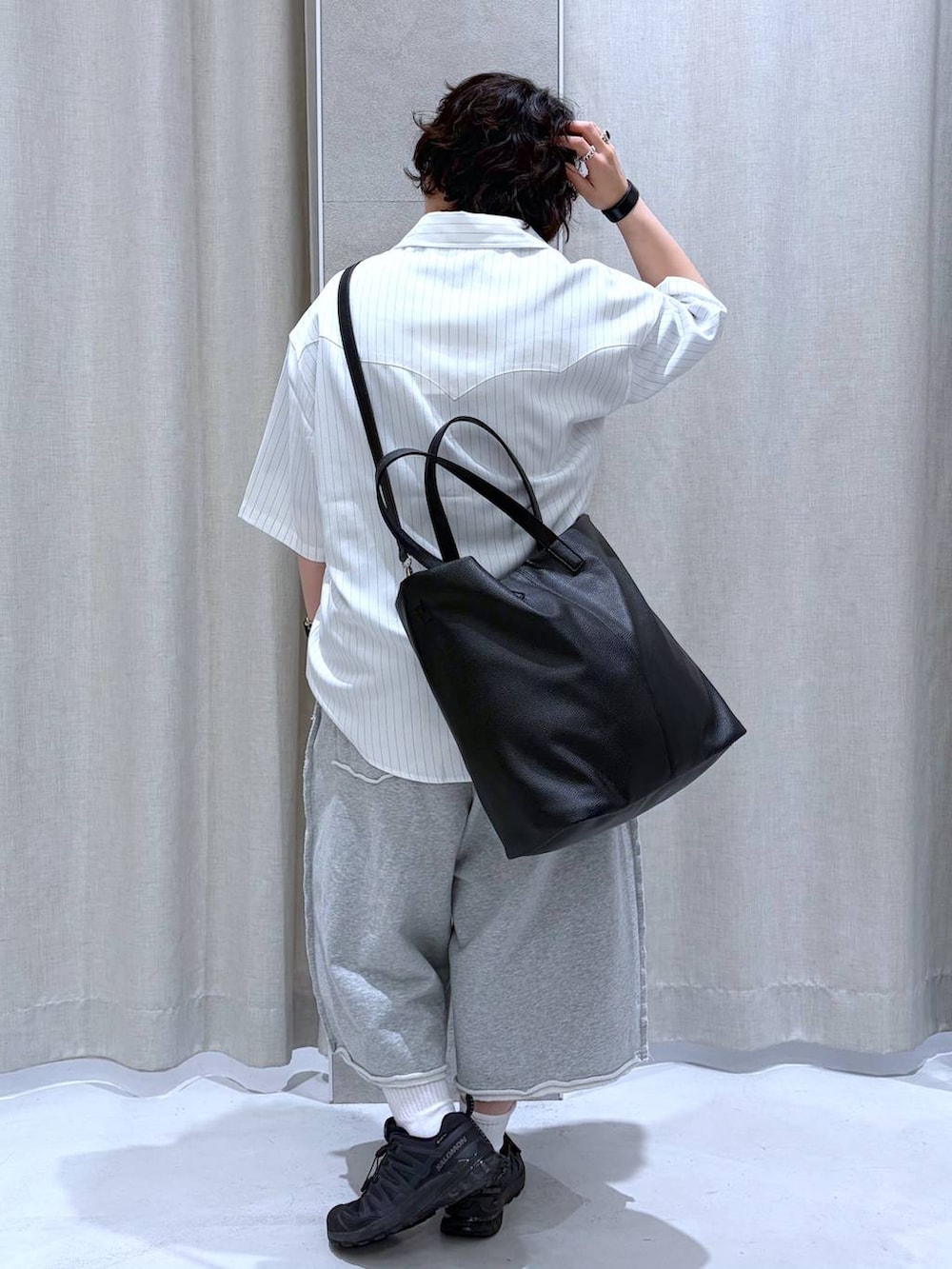 ブラック系のスニーカー、ブラック系のショルダーバッグ、グレー系のスウェットパンツを着用したメンズの夏コーディネートの4枚目の写真