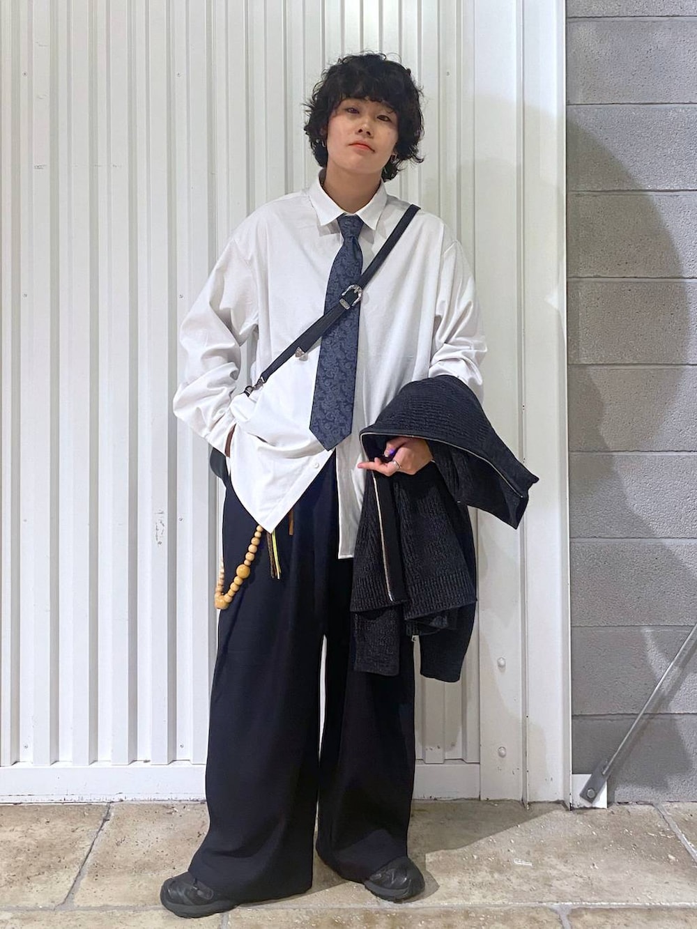 ブラック系のスニーカー、ブラック系のニット/セーター、ブラック系のショルダーバッグを着用したメンズの秋コーディネートの5枚目の写真