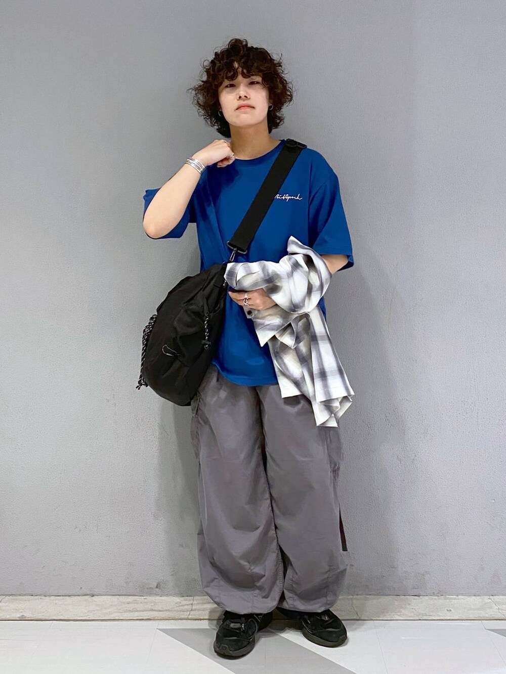 ブラック系のショルダーバッグ、グレー系のカーゴパンツ、ブルー系のTシャツ/カットソーを着用したメンズの夏コーディネートの4枚目の写真