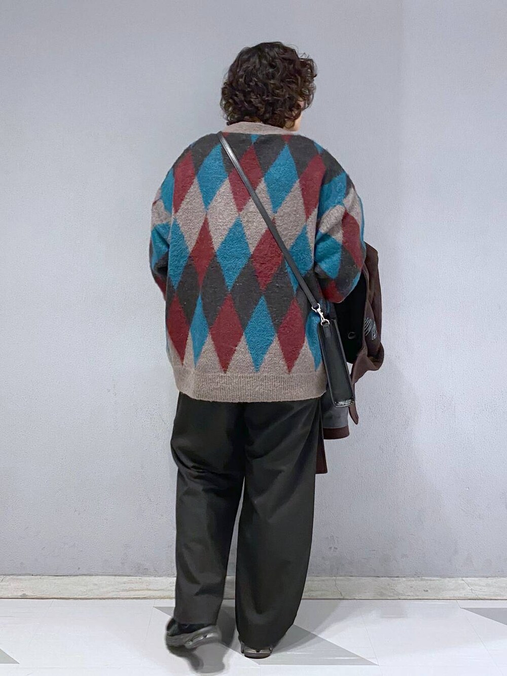 ブラウン系のダッフルコート、ブラウン系のカーディガン/ボレロ、ホワイト系のスウェットを着用したメンズの冬コーディネートの9枚目の写真