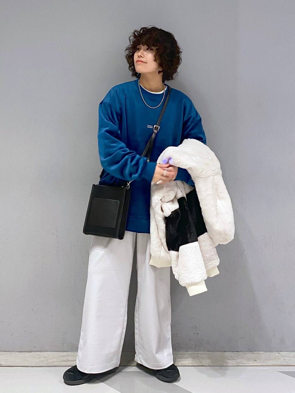 ブルー系のスウェット、ホワイト系のブルゾン、ブラック系のショルダーバッグを着用したメンズの冬コーディネートの6枚目の写真