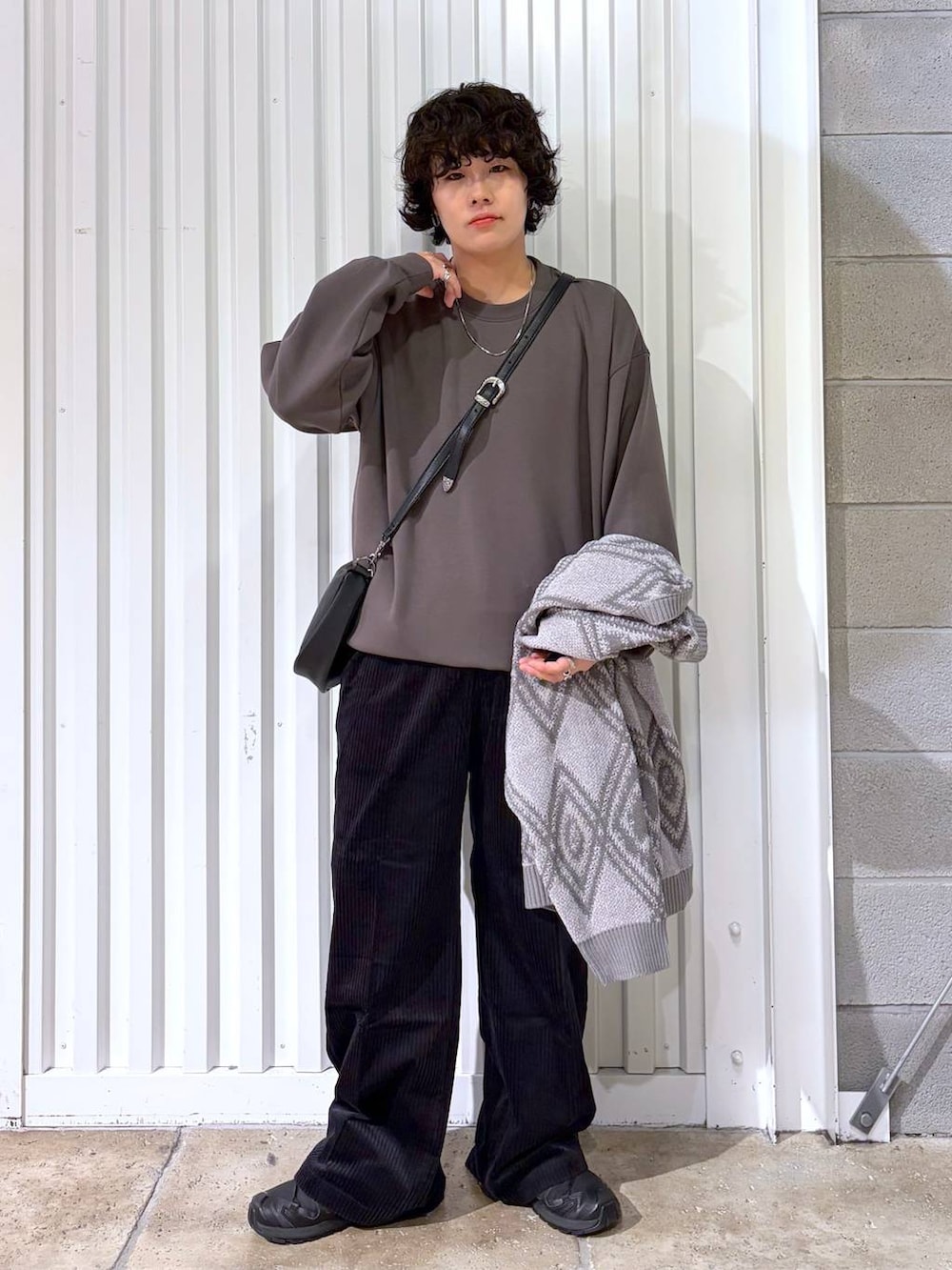 ブラック系のスラックス、ブラウン系のブルゾン、ブラック系のスニーカーを着用したメンズの秋コーディネートの5枚目の写真