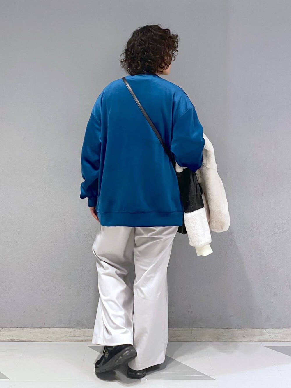 ブルー系のスウェット、ホワイト系のブルゾン、ブラック系のショルダーバッグを着用したメンズの冬コーディネートの9枚目の写真