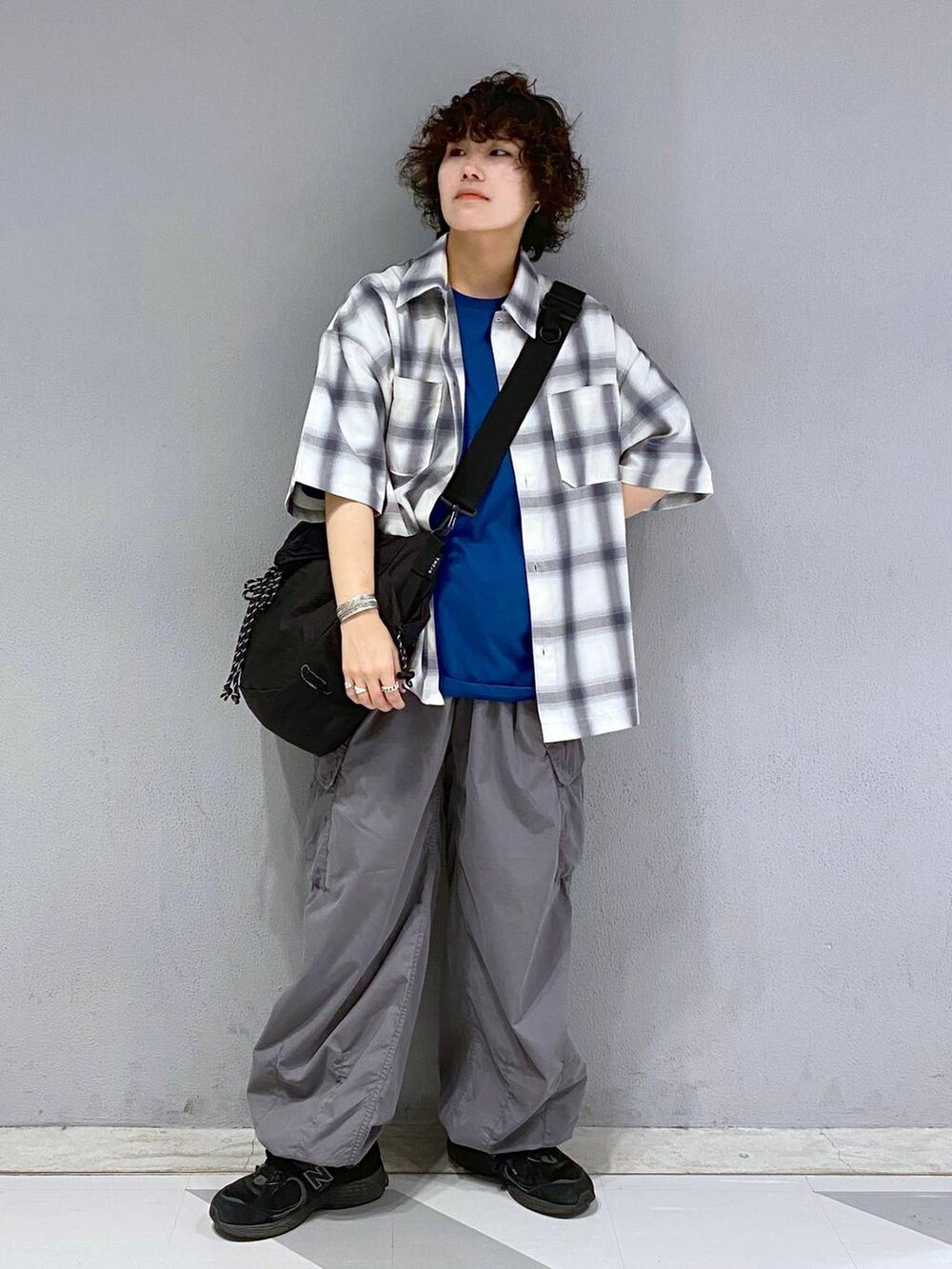 ブラック系のショルダーバッグ、グレー系のカーゴパンツ、ブルー系のTシャツ/カットソーを着用したメンズの夏コーディネートの6枚目の写真