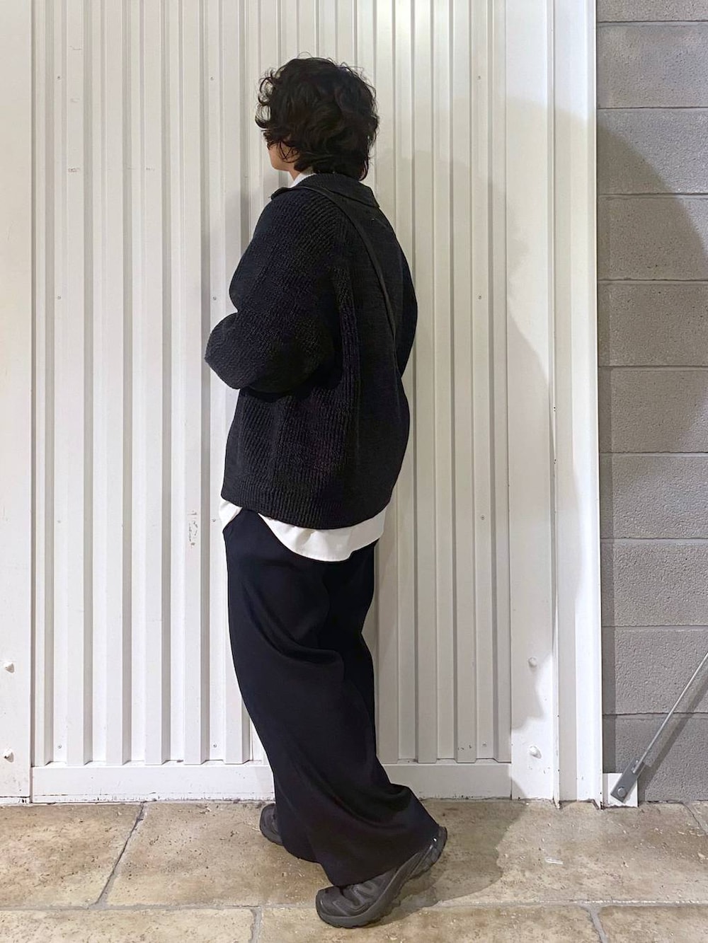 ブラック系のスニーカー、ブラック系のニット/セーター、ブラック系のショルダーバッグを着用したメンズの秋コーディネートの6枚目の写真