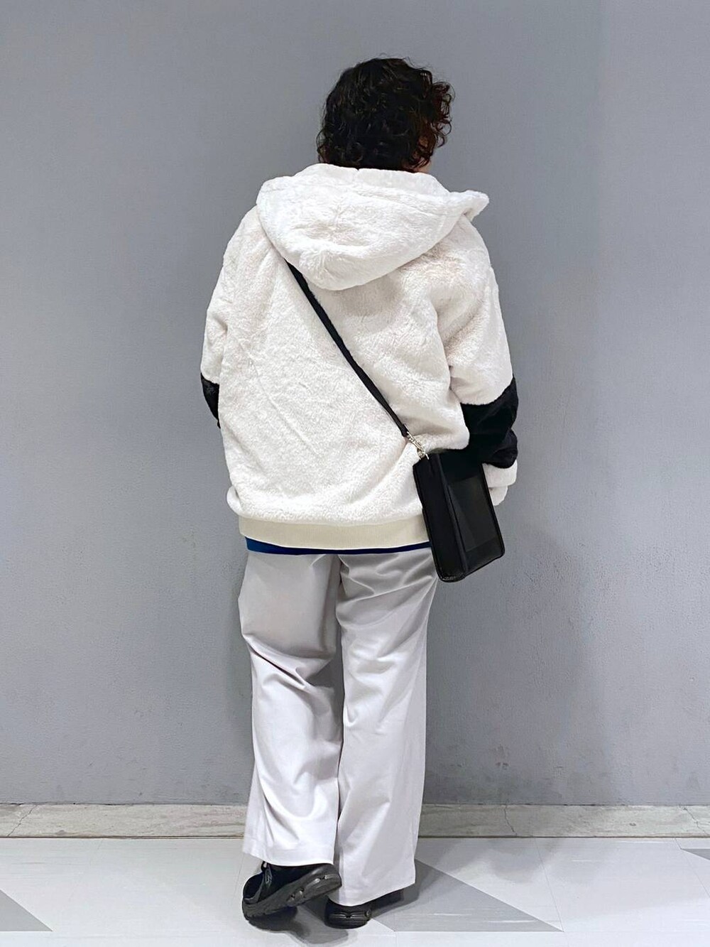 ブルー系のスウェット、ホワイト系のブルゾン、ブラック系のショルダーバッグを着用したメンズの冬コーディネートの9枚目の写真