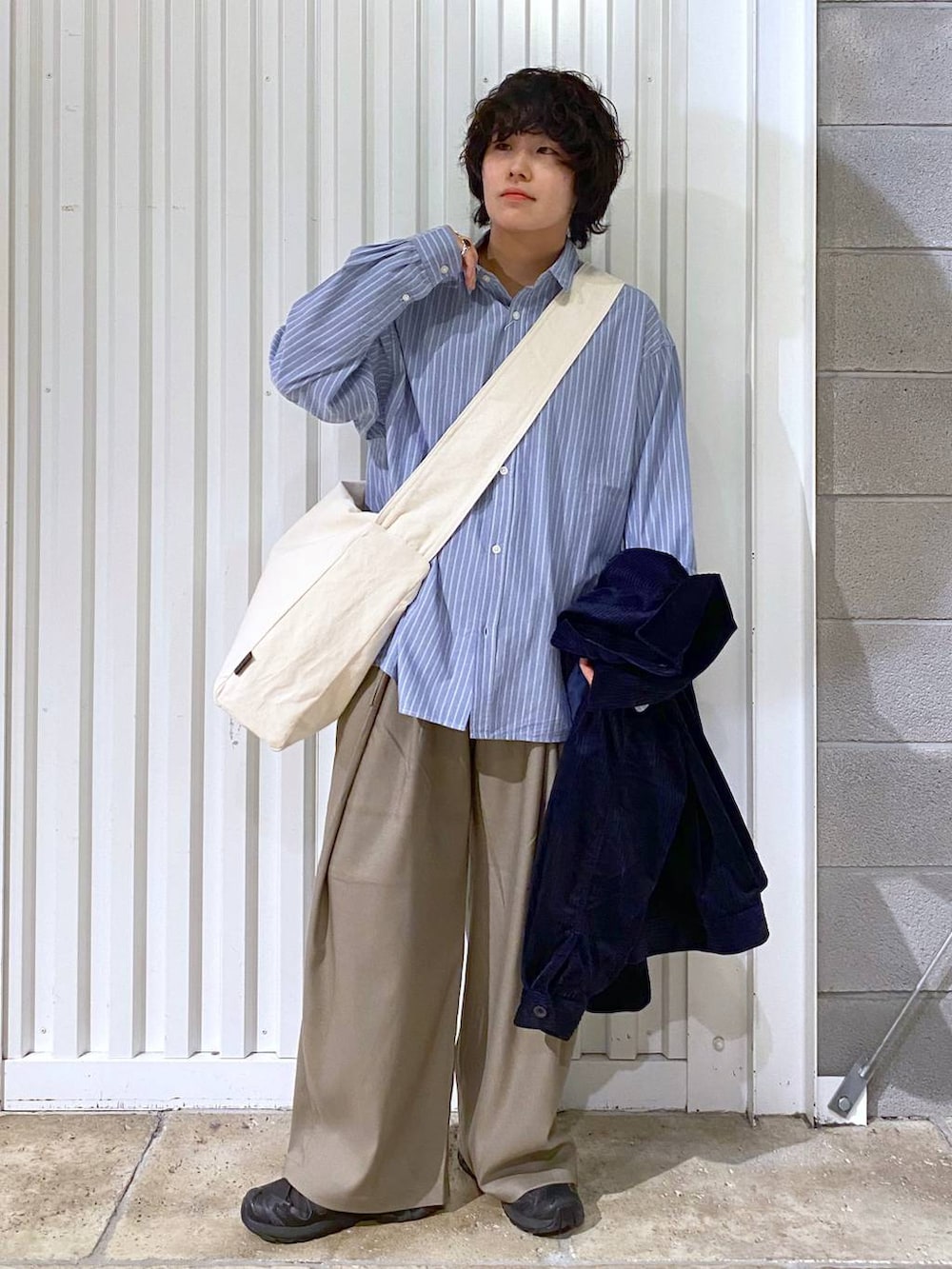 ブラック系のスニーカー、ブルー系のシャツ/ブラウス、その他のショルダーバッグを着用したメンズの秋コーディネートの3枚目の写真