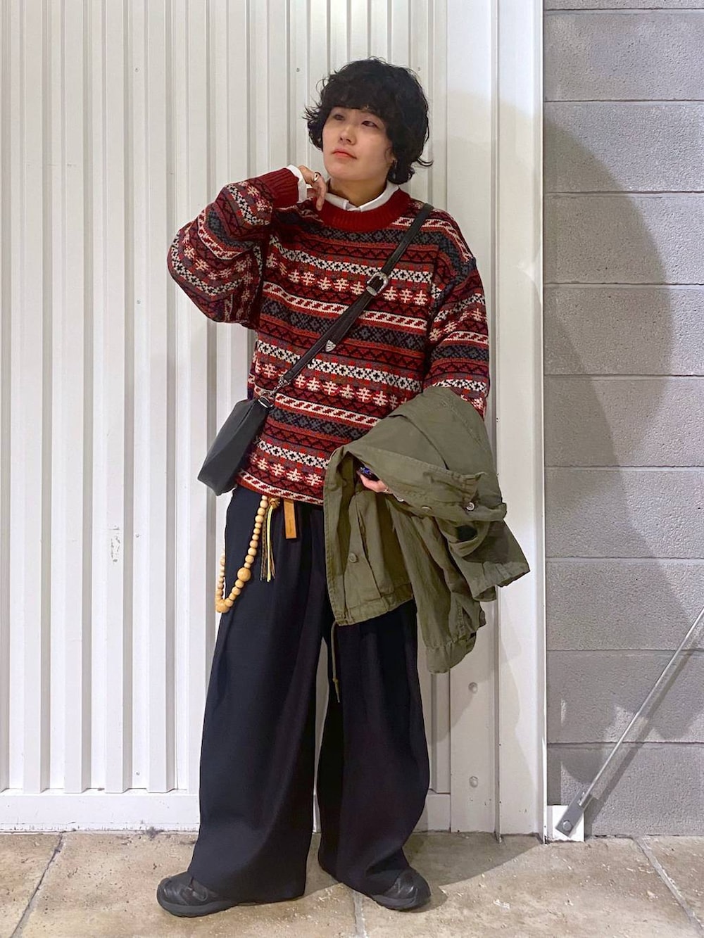 ブラック系のスニーカー、グリーン系のテーラードジャケット、ブラック系のショルダーバッグを着用したメンズの秋コーディネートの5枚目の写真