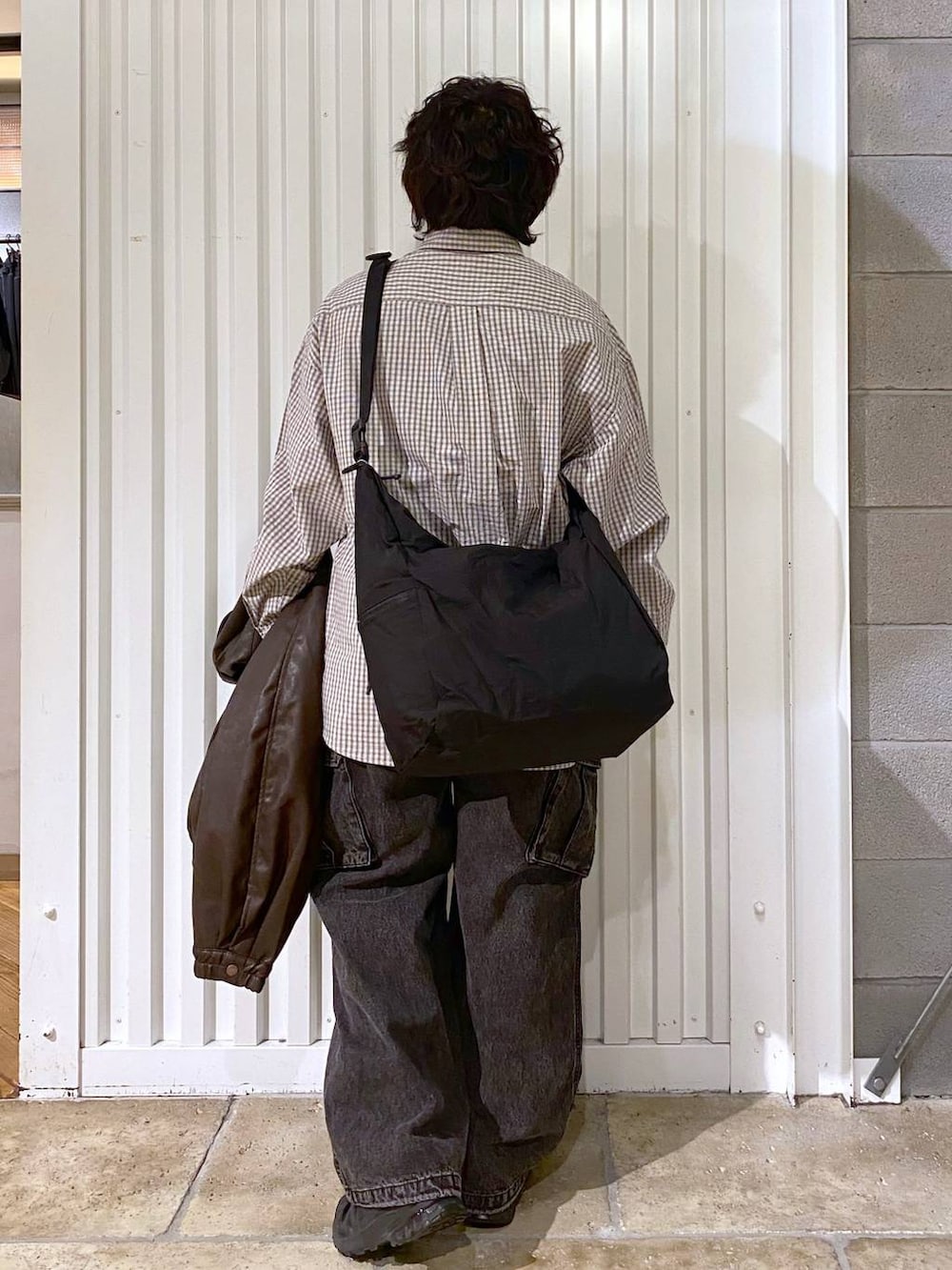 ブラック系のショルダーバッグ、ブラウン系のブルゾン、ブラック系のスニーカーを着用したメンズの秋コーディネートの8枚目の写真