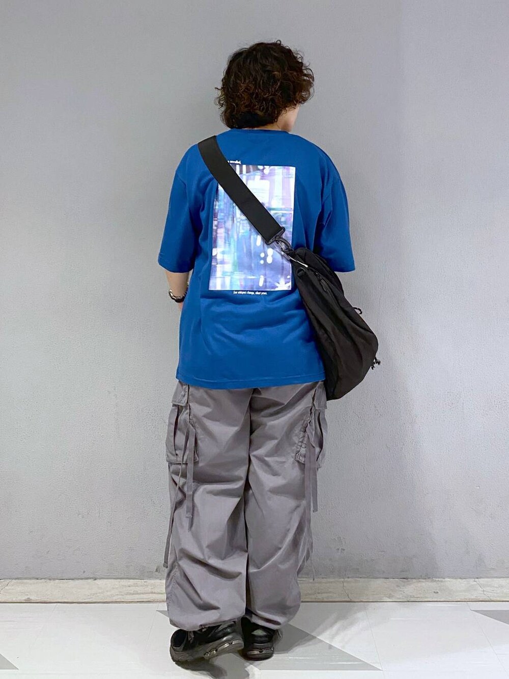 ブラック系のショルダーバッグ、グレー系のカーゴパンツ、ブルー系のTシャツ/カットソーを着用したメンズの夏コーディネートの5枚目の写真
