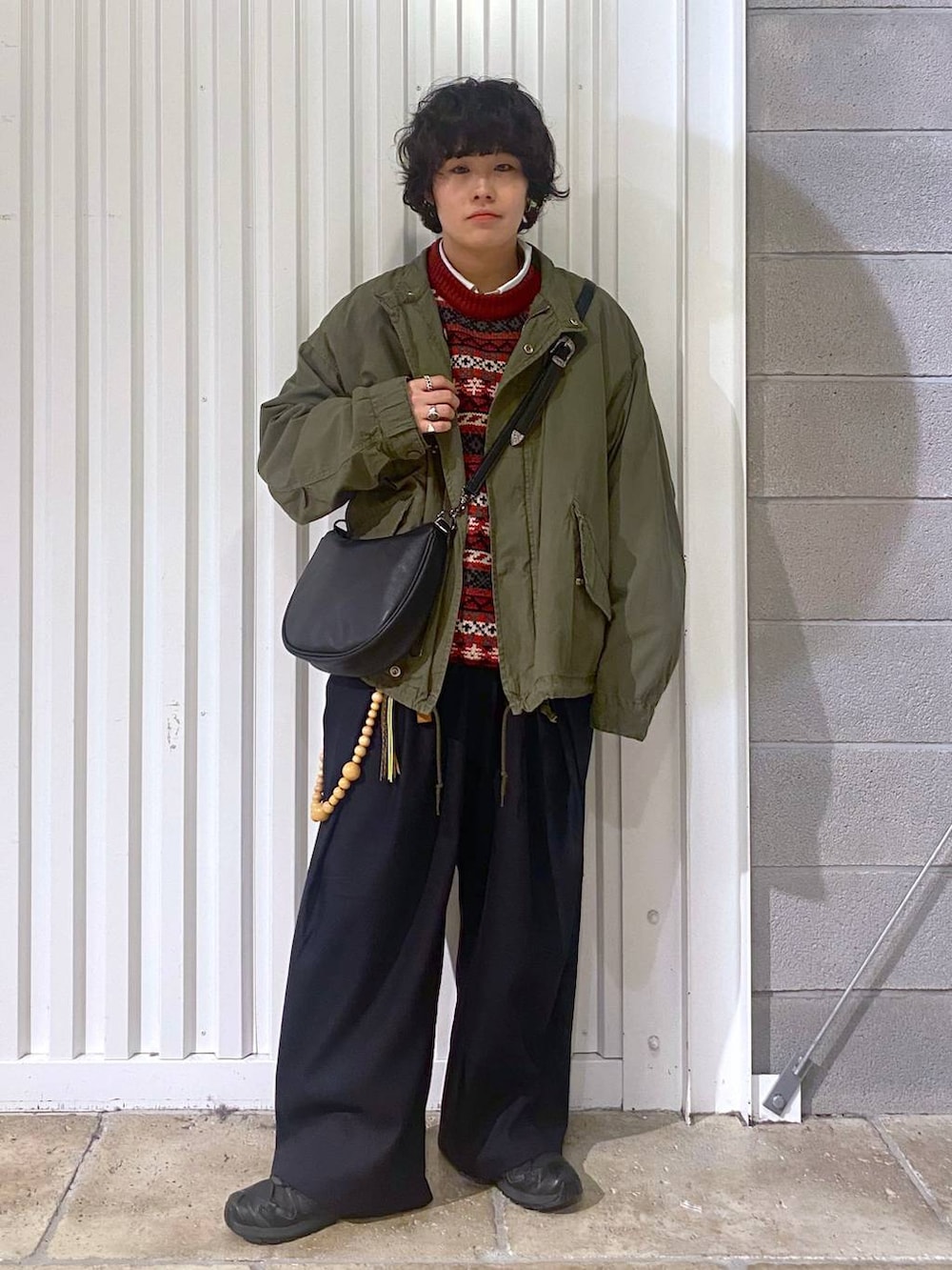 ブラック系のスニーカー、グリーン系のテーラードジャケット、ブラック系のショルダーバッグを着用したメンズの秋コーディネートの3枚目の写真