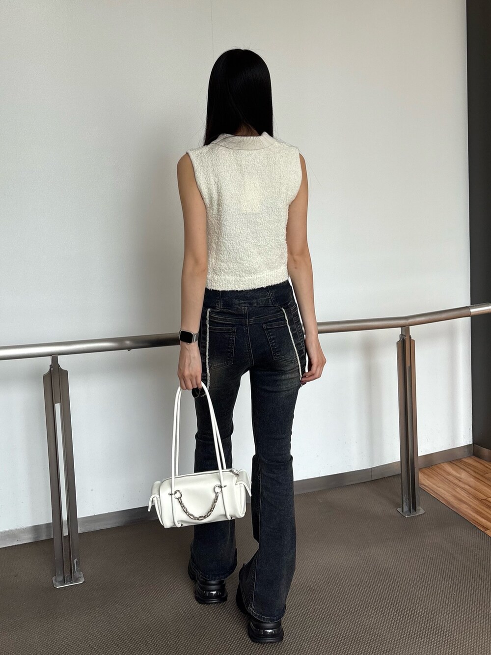 ブルー系のデニムパンツ、ホワイト系のニット/セーター、ブラック系のサンダルを着用したレディースの夏コーディネートの3枚目の写真